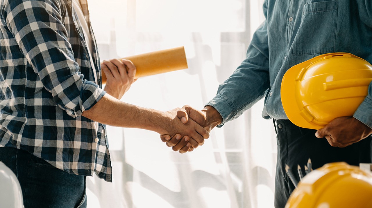 A closeup shot of a handshake between a contractor and a homeowner. construction fraud
