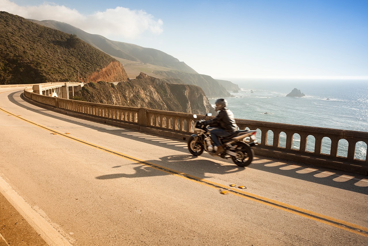 A motorcycle driving over a bridge in Big Sur on the California coast. motorcycle safety