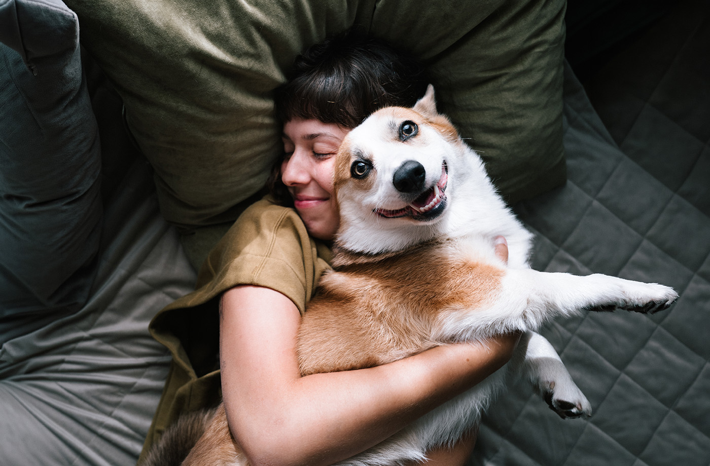Woman hugging her corgi dog