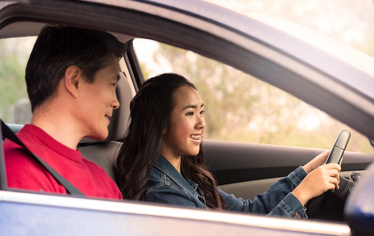A teenage girl in the drivers seat during a driving lesson. teen driver